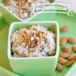 Almond Rice pudding in a bowl with almonds next to it on a plate