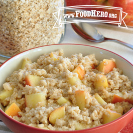 Bowl of apple spice oatmeal next to glass container of oatmeal