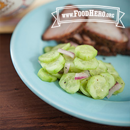 summer cucumbers on a dinner plate next to sliced meat