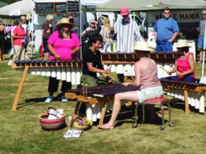 outdoor festival with people playing large xylophones