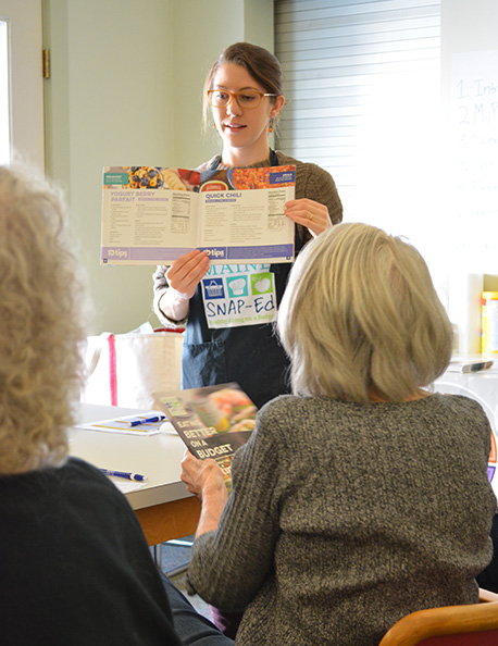 Staff member showing handout of healthy options to students