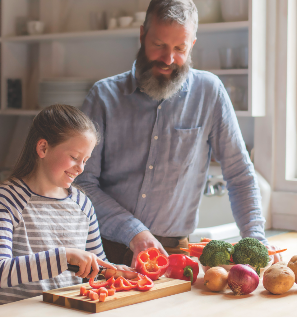 father and daughter chopping vegetables