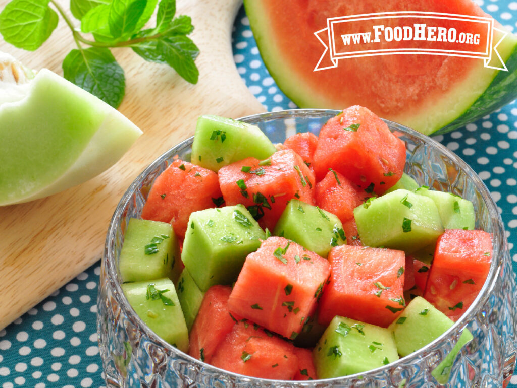 glass bowl of cut melon and mint