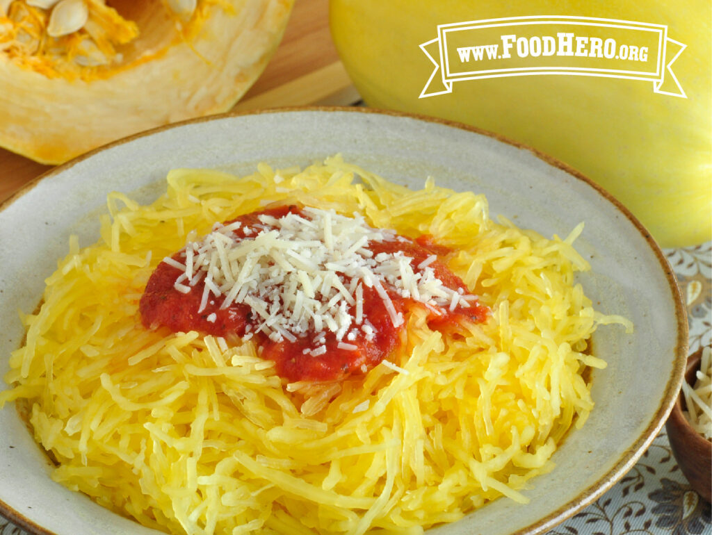 ceramic bowl filled with spaghetti squash with tomato sauce and parmesan cheese sprinkled on top