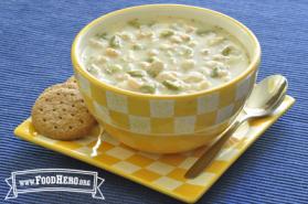 bowl of white chicken chili on plate with crackers and a spoon