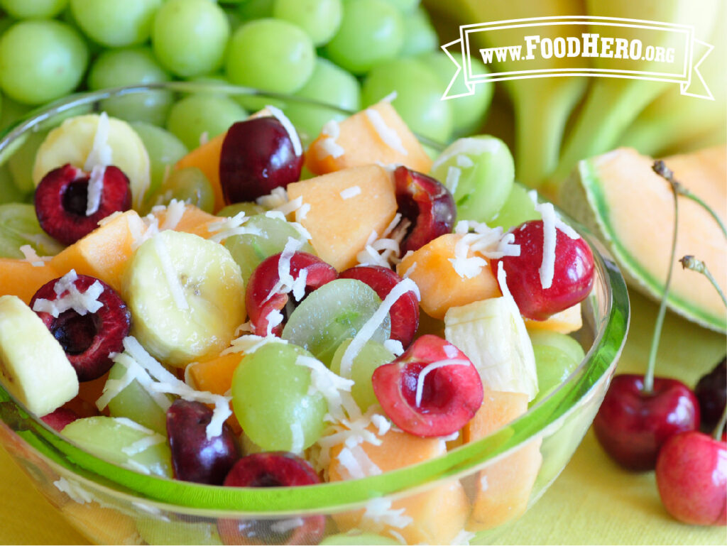 bowl of cherry salad next to fresh grapes