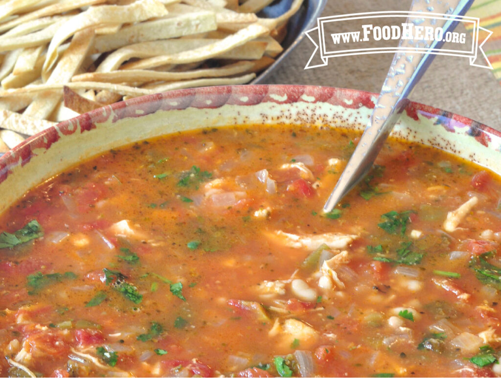 bowl of chicken soup with tortilla