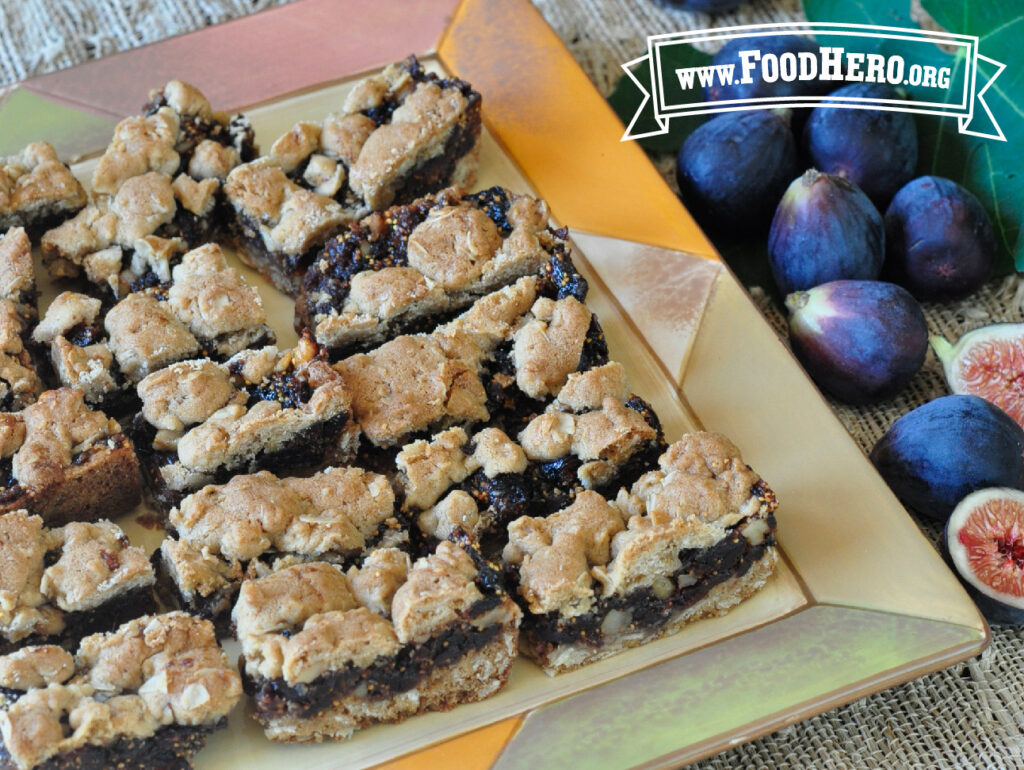 serving plate of sliced fabulous fig bars next to fresh figs