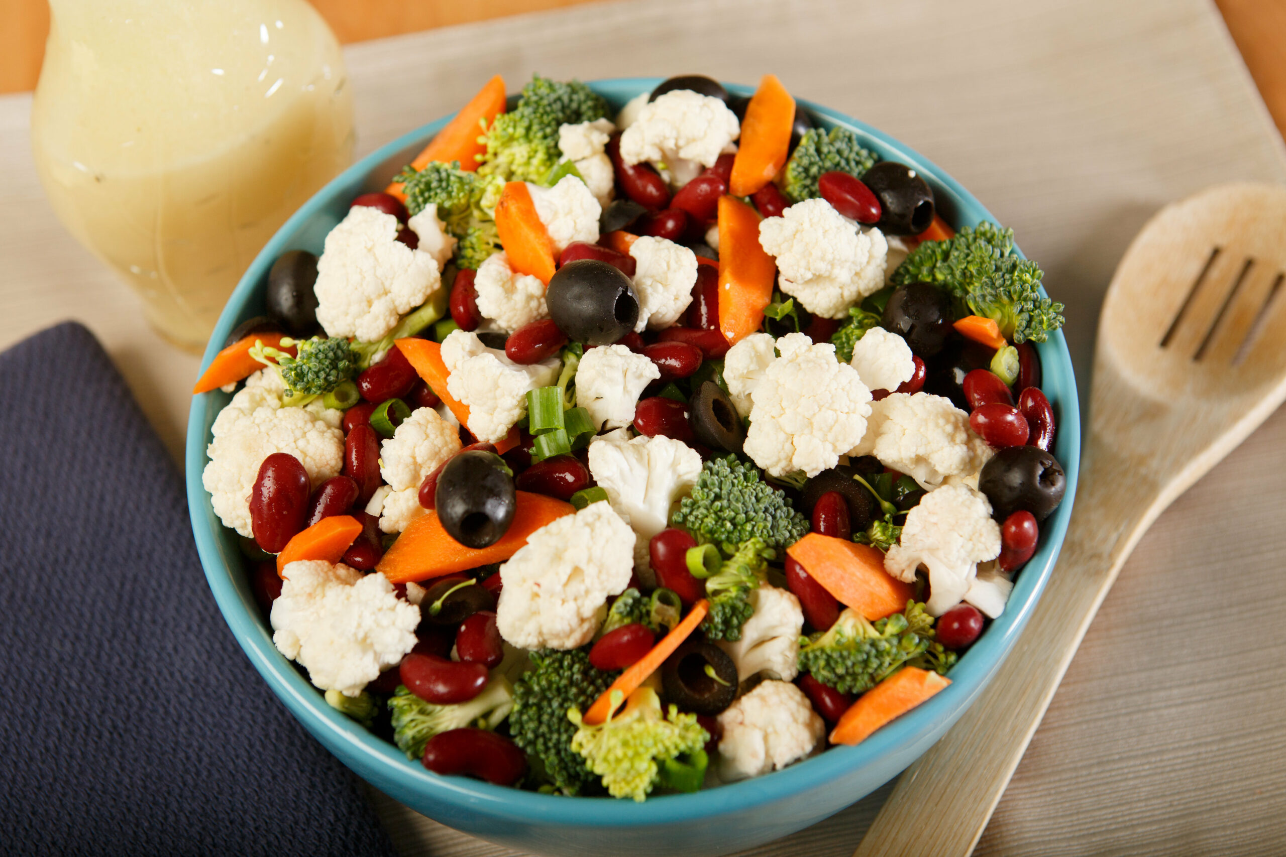 bowl of harvest vegetable salad with wooden serving spoon