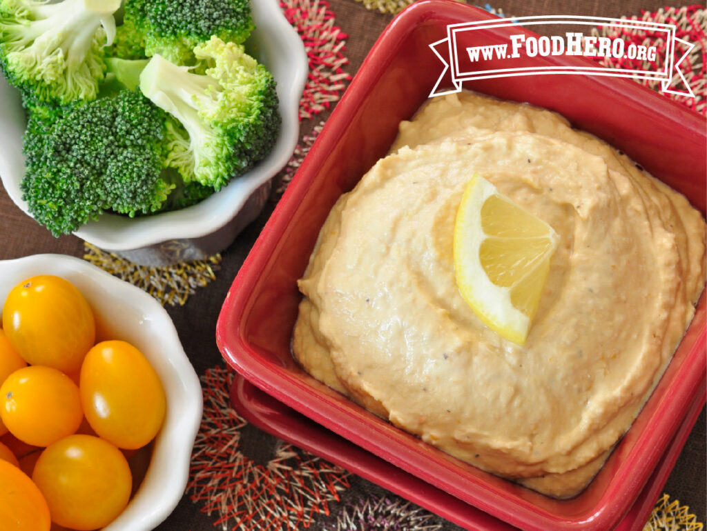 bowl of hummus with fresh broccoli and grape tomatoes