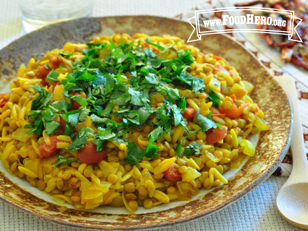 turmeric lentils and pasta on a plate with a serving spoon