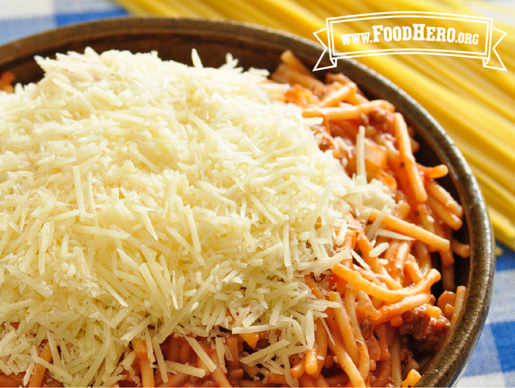 bowl of one pan spaghetti with shredded cheese on top