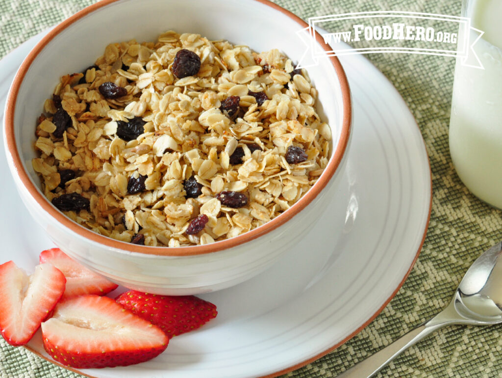 Cereal bowl of skillet granola with a side of sliced fresh strawberries