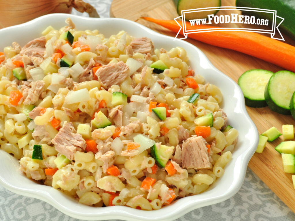 bowl of tuna pasta salad next to fresh vegetables