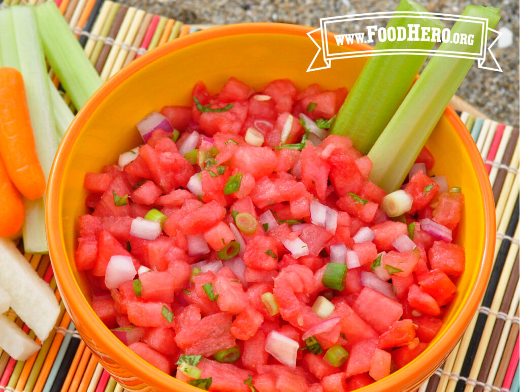 bowl of watermelon salsa with 2 celery stalks in it