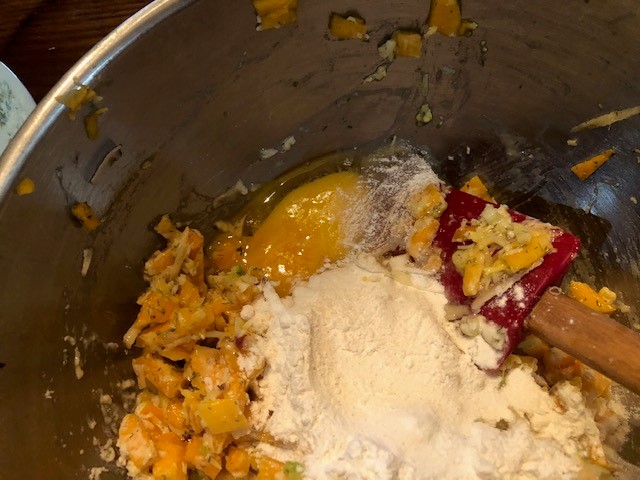 mixing bowl of butternut squash with flour cheese and egg