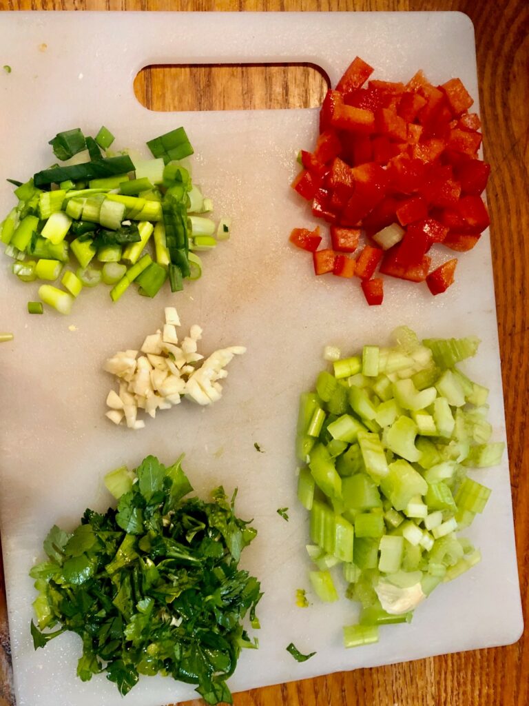 cut vegetables in piles on a cutting board