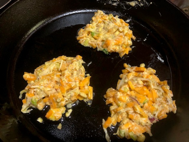 vegetable cakes being cooked in fry pan
