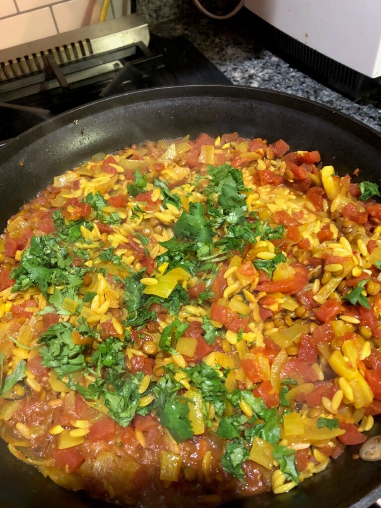 cooked turmeric lentils and pasta in the skillet on stovetop